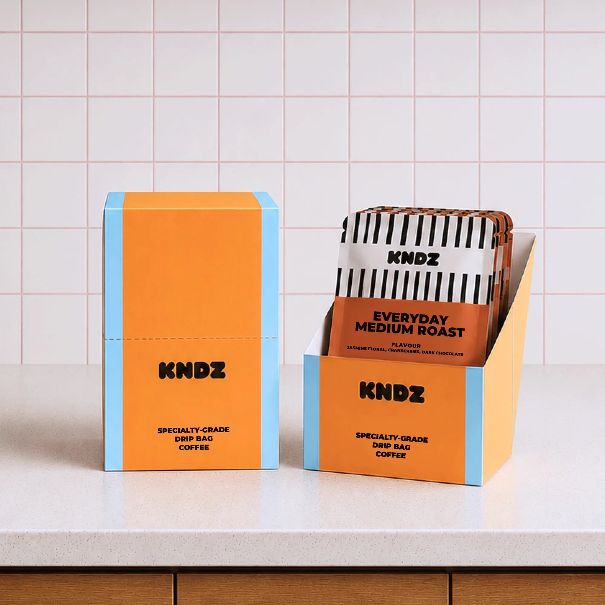 Sealed KNDZ drip bag coffee packs showing the printed roast month