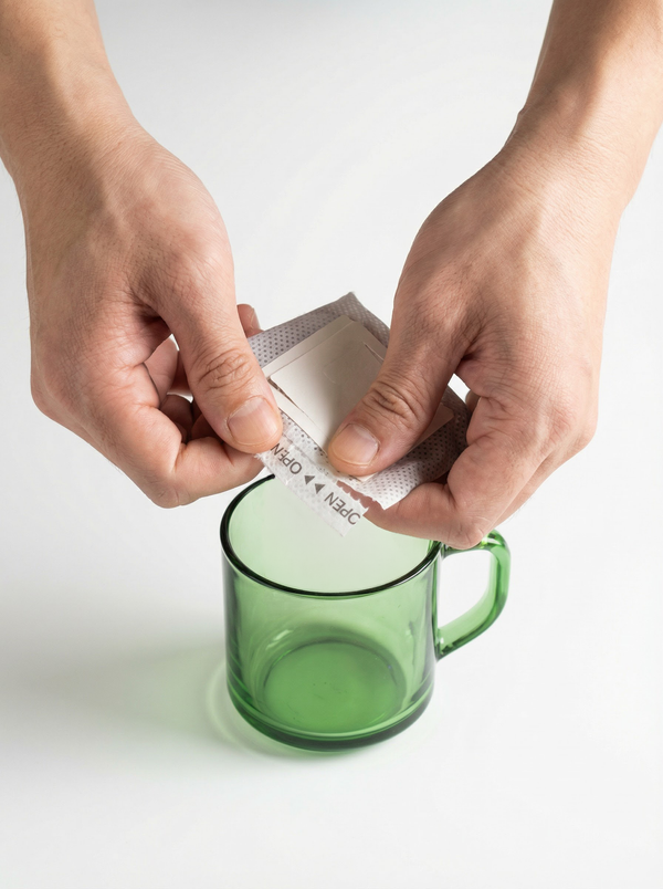 Opening a KNDZ COFFEE drip bag packet